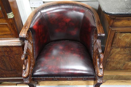 A pair of French Empire style carved mahogany and brass studded leather tub shaped armchairs,